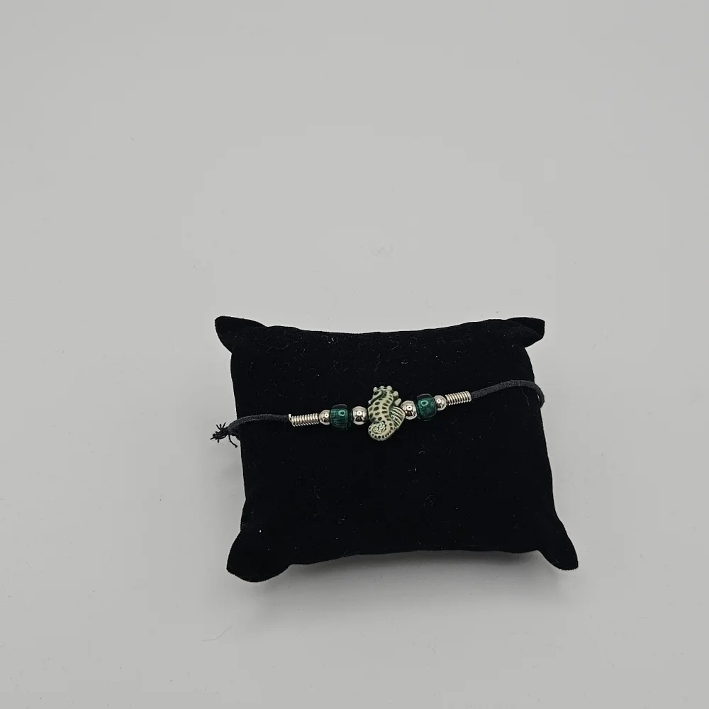black slider bracelet with green and cream seahorse bead